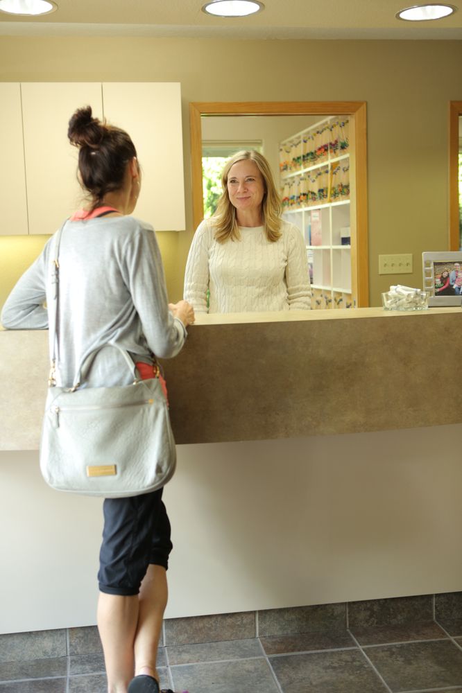 A patient at reception talking to the receptionist at Roane Family Dental.