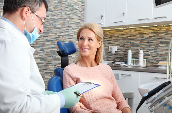 Woman talking to dentist during dental exam at Roane Family Dental in West Linn, OR