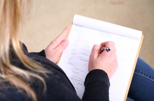 Woman filling out insurance paperwork at Roane Family Dental in West Linn, OR