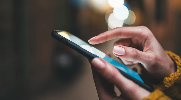 Close up of slender hands scrolling through a smart phone Roane Family Dental.