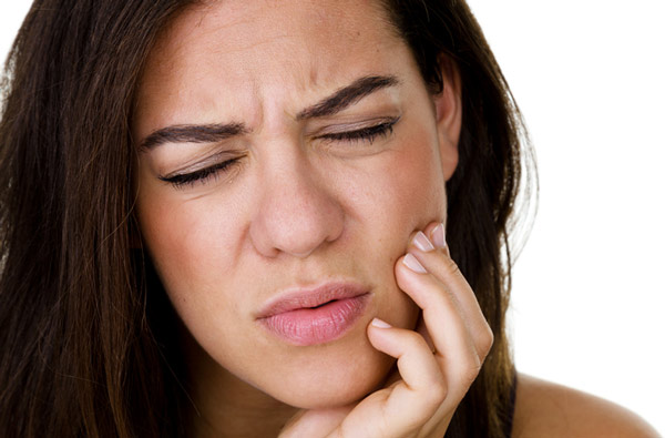 A woman with TMJ holding her jaw at Roane Family Dental in West Linn, OR